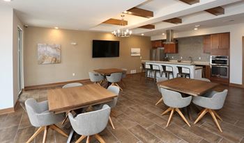 a dining room and kitchen with two tables and chairs